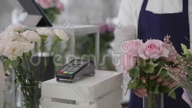 非接触式支付，在花店买家使用手机支付终端花束，小企业